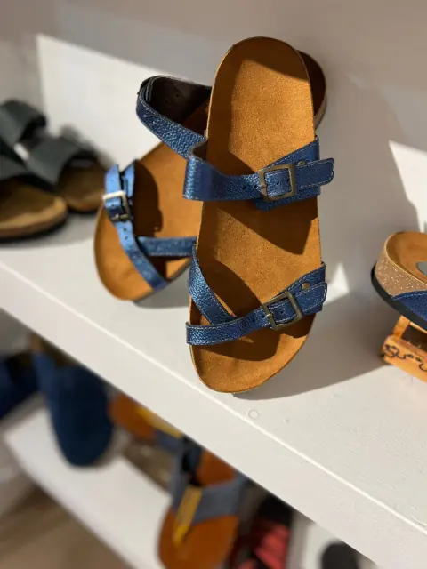 Sandalias artesanales en una repisa blanca